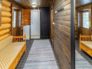 A log cabin interior with a sofa, a refrigerator, and a door. - Joutsen by Interhome (Puumala)