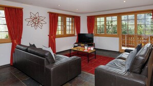 Una sala de estar con dos sofás de cuero, un televisor y una mesa de centro.