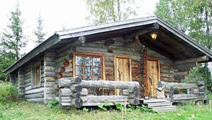 A rustic log cabin with a porch, wooden doors, and a chimney.