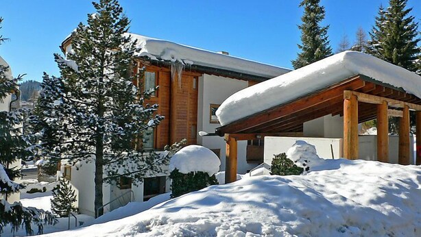 A snow-covered building with a wooden exterior and a covered outdoor area. - Apartment Girun by Interhome (Flims)