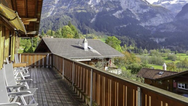 Ein Holzbalkon mit Blick auf ein Gebirge.