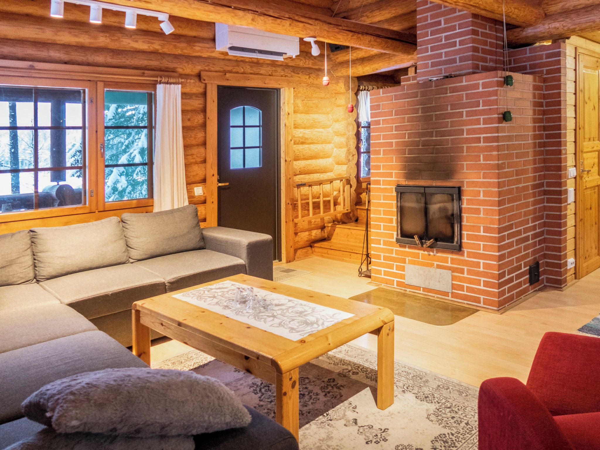 L’intérieur d’un chalet confortable, avec une cheminée, un canapé et une table basse.