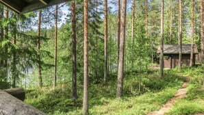 Eine Hütte im Wald, verbunden durch einen Feldweg.