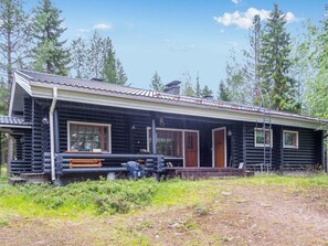 A log cabin with a porch, a bench, and a door. - Imponlampi by Interhome (Kuusamo)