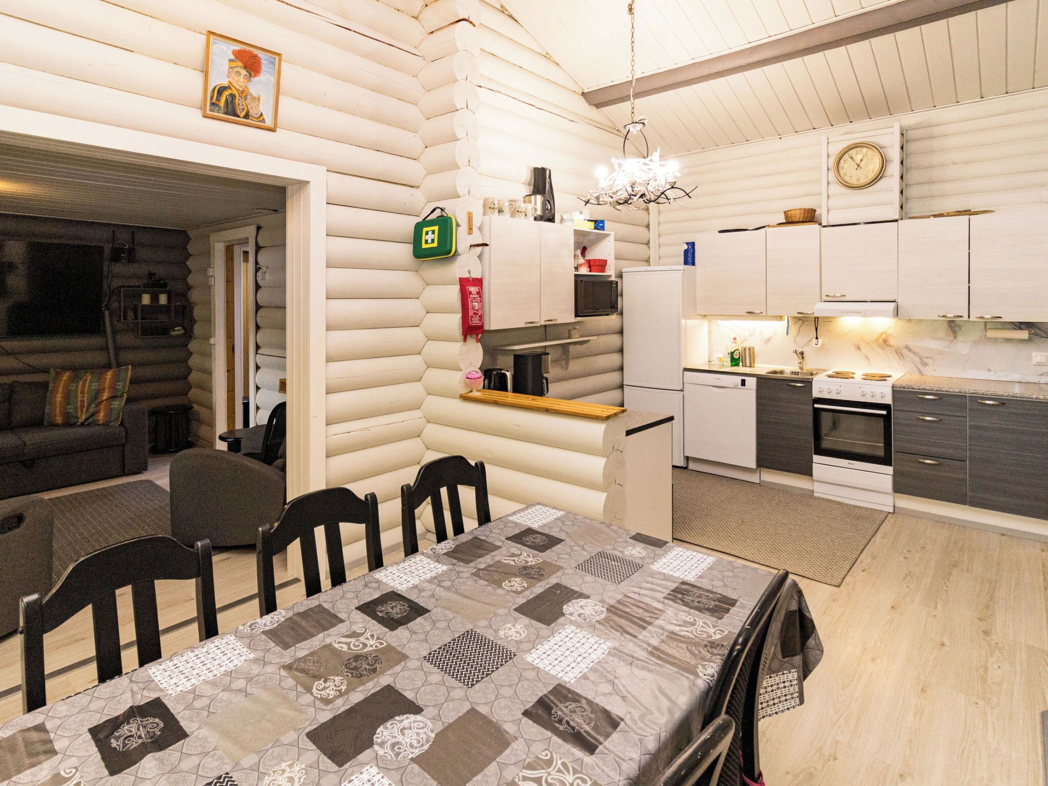 Interior de una cabaña de troncos con comedor, cocina y sala de estar.