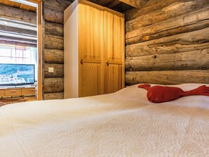 Een kamer met een bed, een houten kast en een raam met uitzicht op een boot.