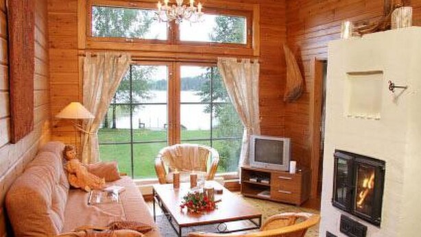 A cozy cabin interior with a sofa, chairs, a table, a television, and a fireplace. - Alahuone by Interhome (Asikkala)