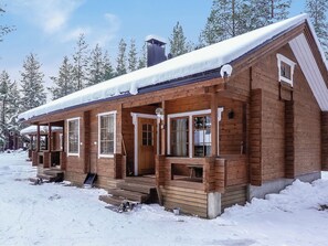 A wooden cabin with a porch, multiple windows, and a chimney. - Aslakit b by Interhome (Kittilä)
