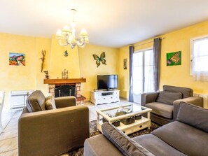 Ein Wohnzimmer mit Kamin, Fernseher und zwei Sofas.