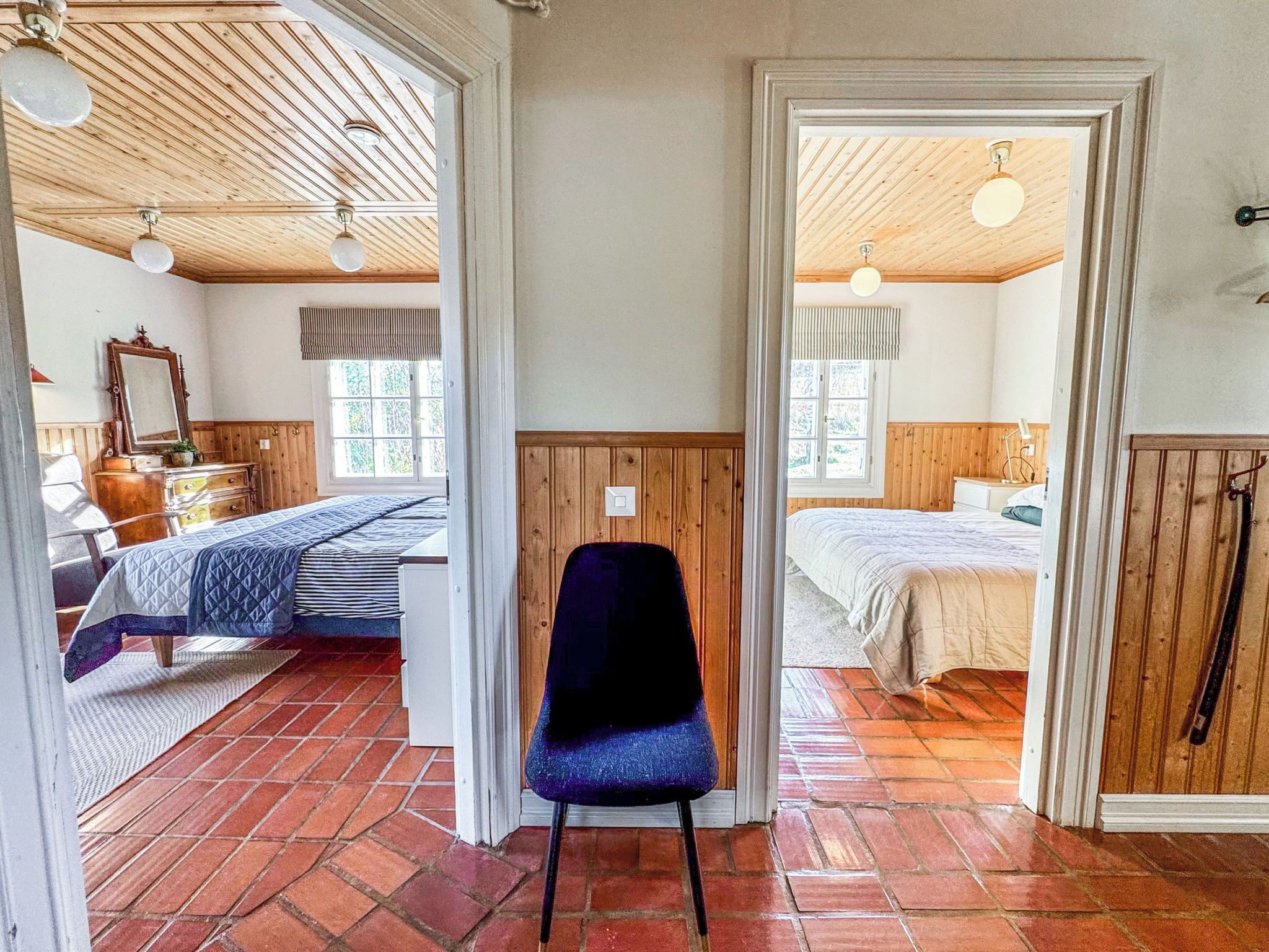 Une pièce avec un lit, une chaise et un plafond en bois.