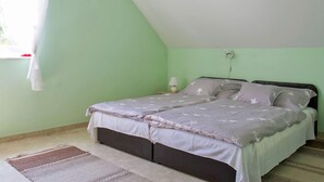 A bedroom with a bed, a nightstand, a lamp, and a window with a curtain. - Vacation home Welle by Interhome (Balatonmariafurdo)