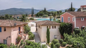 A residential area with a swimming pool, terraced houses, and a mountainous backdrop. - Le Golf de Roquebrune by Interhome (Roquebrune sur Argens)