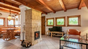 Un salon chaleureux avec une cheminée, des meubles en bois et de grandes fenêtres.