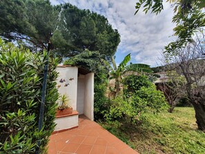 A garden pathway leading to a white building with a tiled floor. - Orchidea by Interhome (Siracusa)