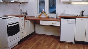 A kitchen with white appliances, wooden countertops, and a window with a view. - Eteläranta by Interhome (Hankasalmi)