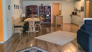 A modern living room with a dining area, a kitchen, and a bookshelf. - Am Ryschbächli by Interhome (Zweisimmen)