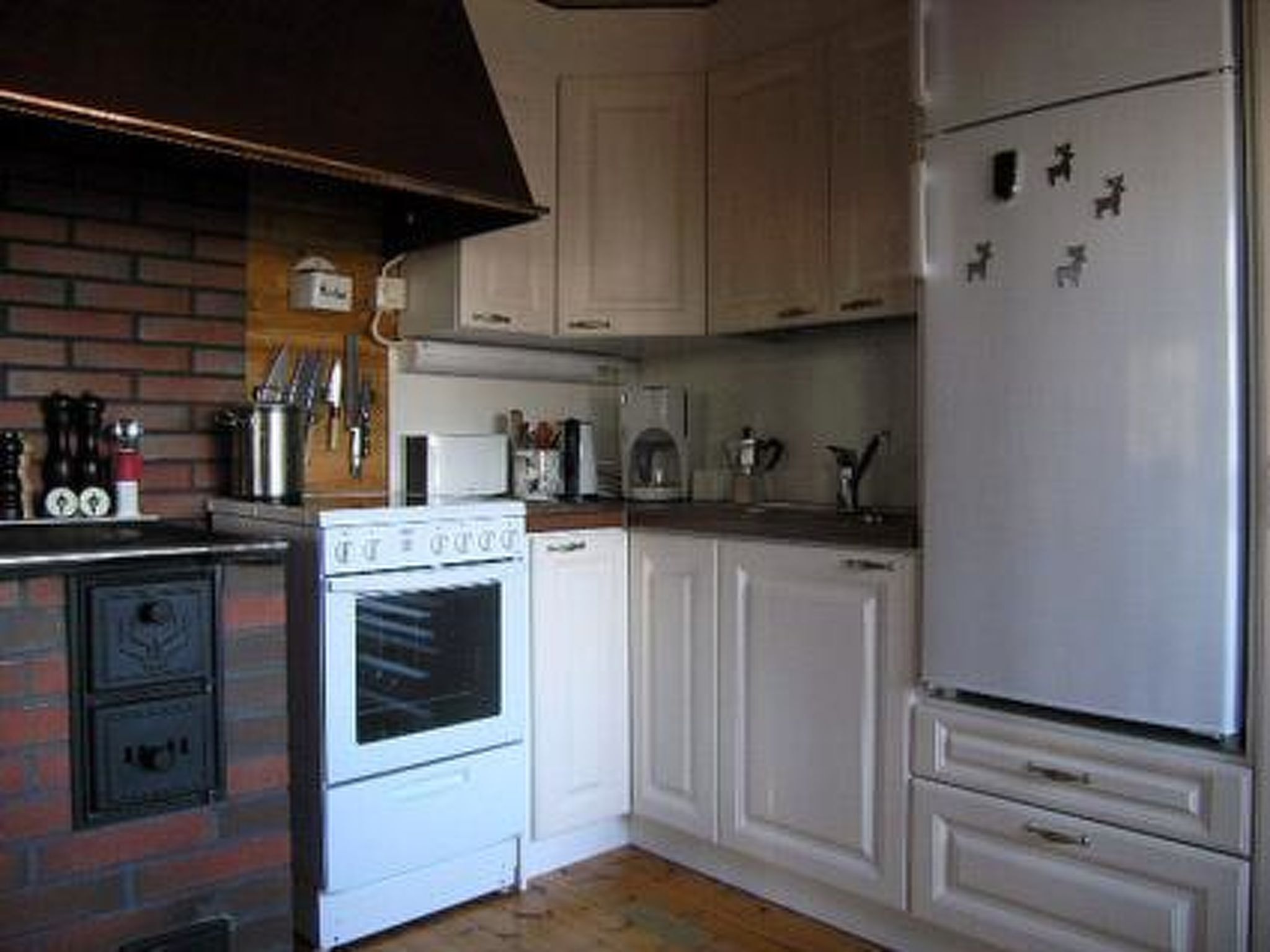 Una cocina equipada con estufa, horno, microondas y refrigerador.