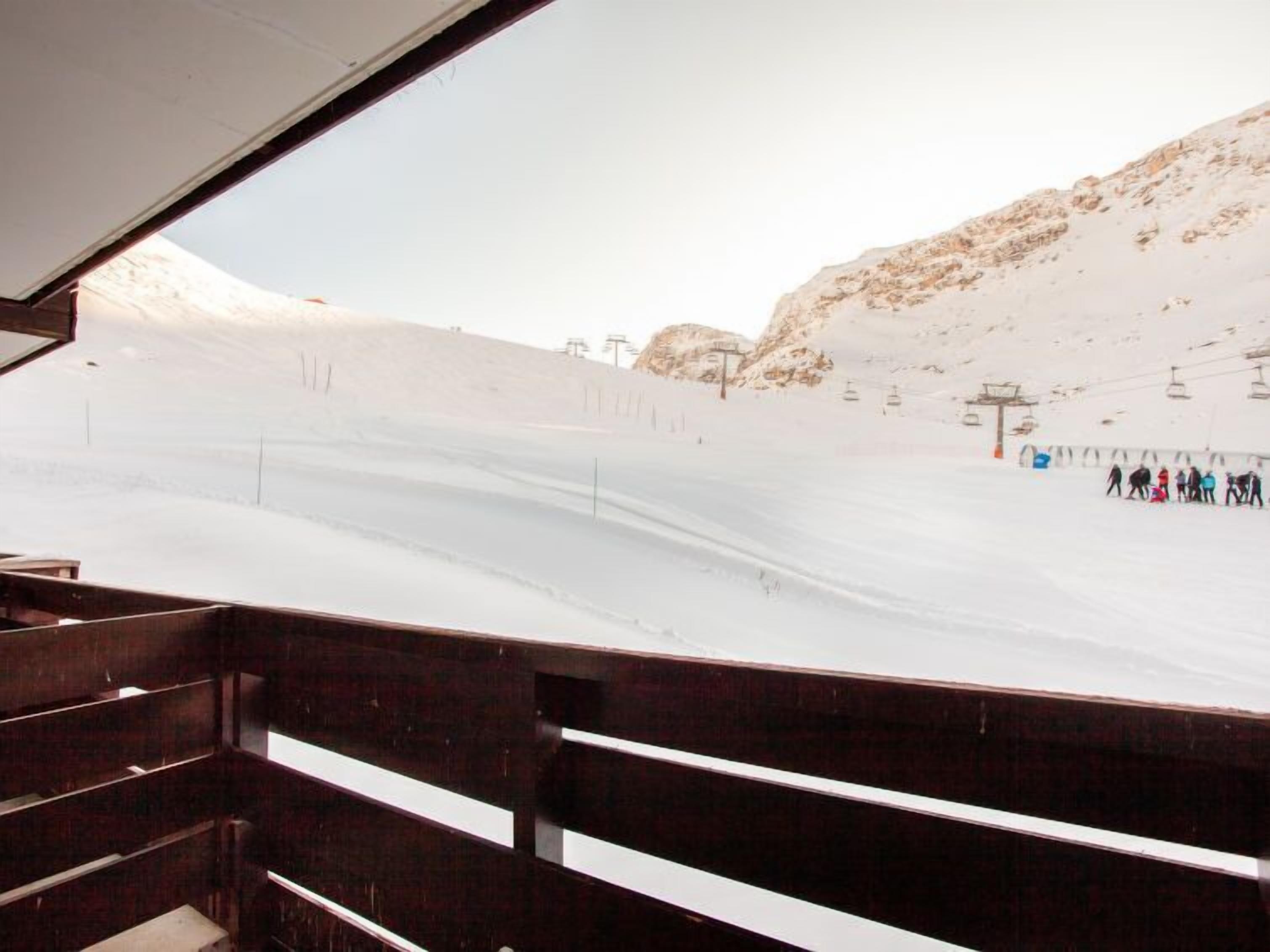 A snowy ski slope with a chairlift and skiers.