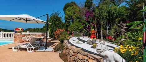 A pool area with lounge chairs and a statue.