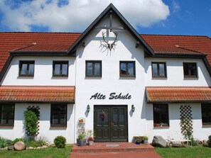 A two-story building with a red-tiled roof and a sign reading "Alte Schule".