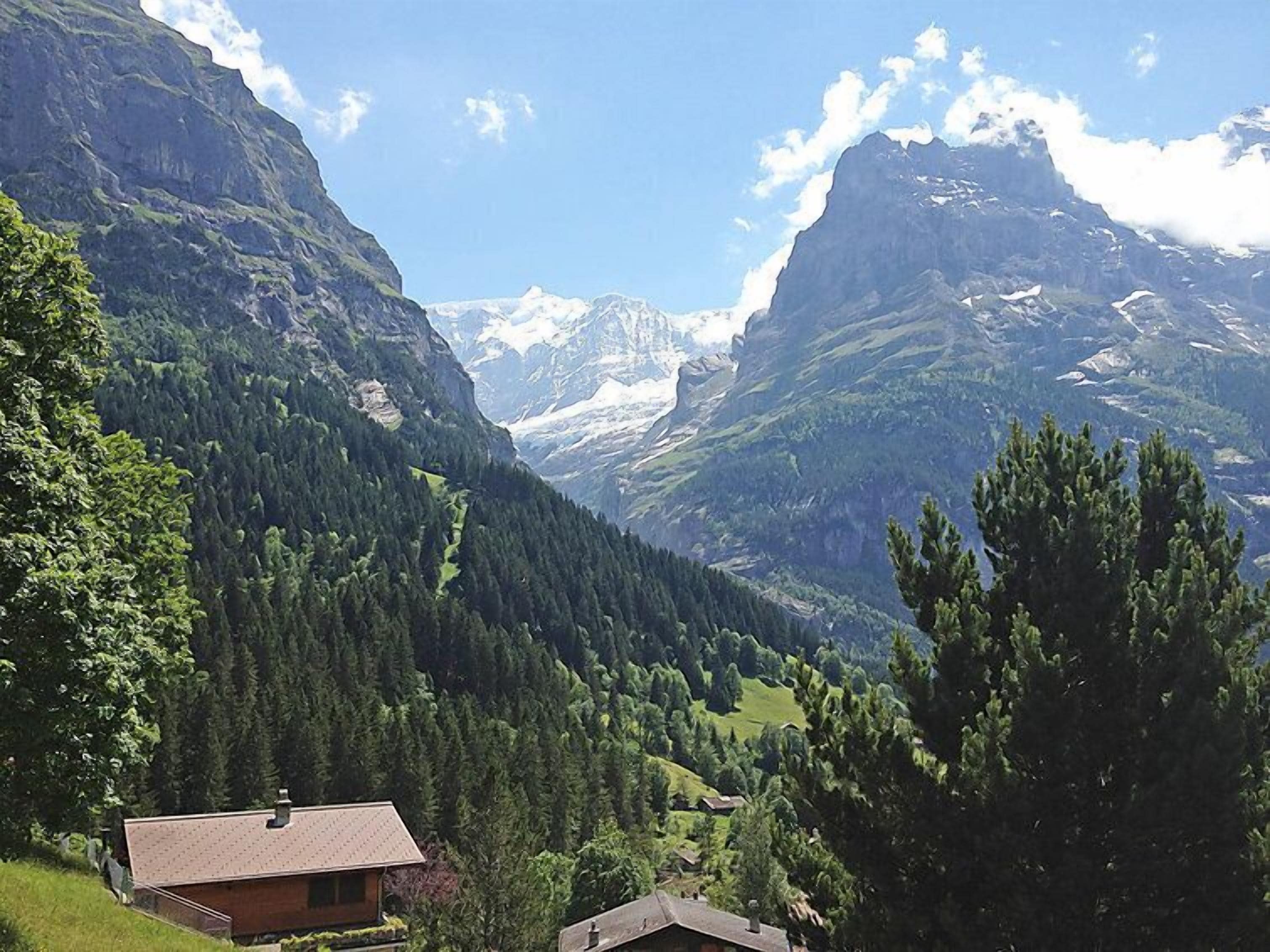Un paysage de montagne avec une maison au premier plan.