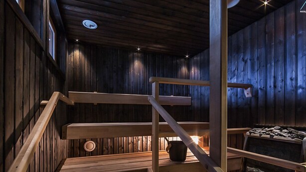 Un interior de madera con una escalera, una chimenea y un detalle de piedra.