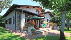 Une maison dotée d’un patio, d’un espace salon extérieur et de plantes en pot.