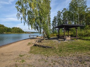 Un parc au bord du lac, doté d’un kiosque en bois, d’une plage de sable et d’une jetée qui s’avance dans l’eau.