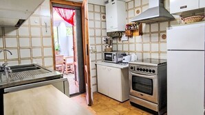 A compact kitchen with a sink, stove, microwave, and a refrigerator. - Barracuda by Interhome (Grosseto)
