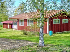 A red wooden house with a sloped roof, a small porch, and a number '19' sign. - Rantaheikari by Interhome (Hämeenlinna)