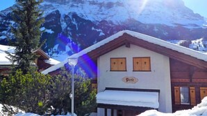A mountain lodge with a snow-covered roof, wooden shutters, and a sign reading "Bergele". - Chalet Perle by Interhome (Grindelwald)