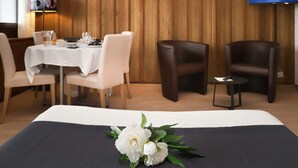 A hotel room with a bed, a dining table with chairs, a TV, and a wooden wall. - Gamat 30 by Interhome (Villars)