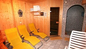 Een houten kamer met drie gele stoelen, een witte stoel en een stenen muur.