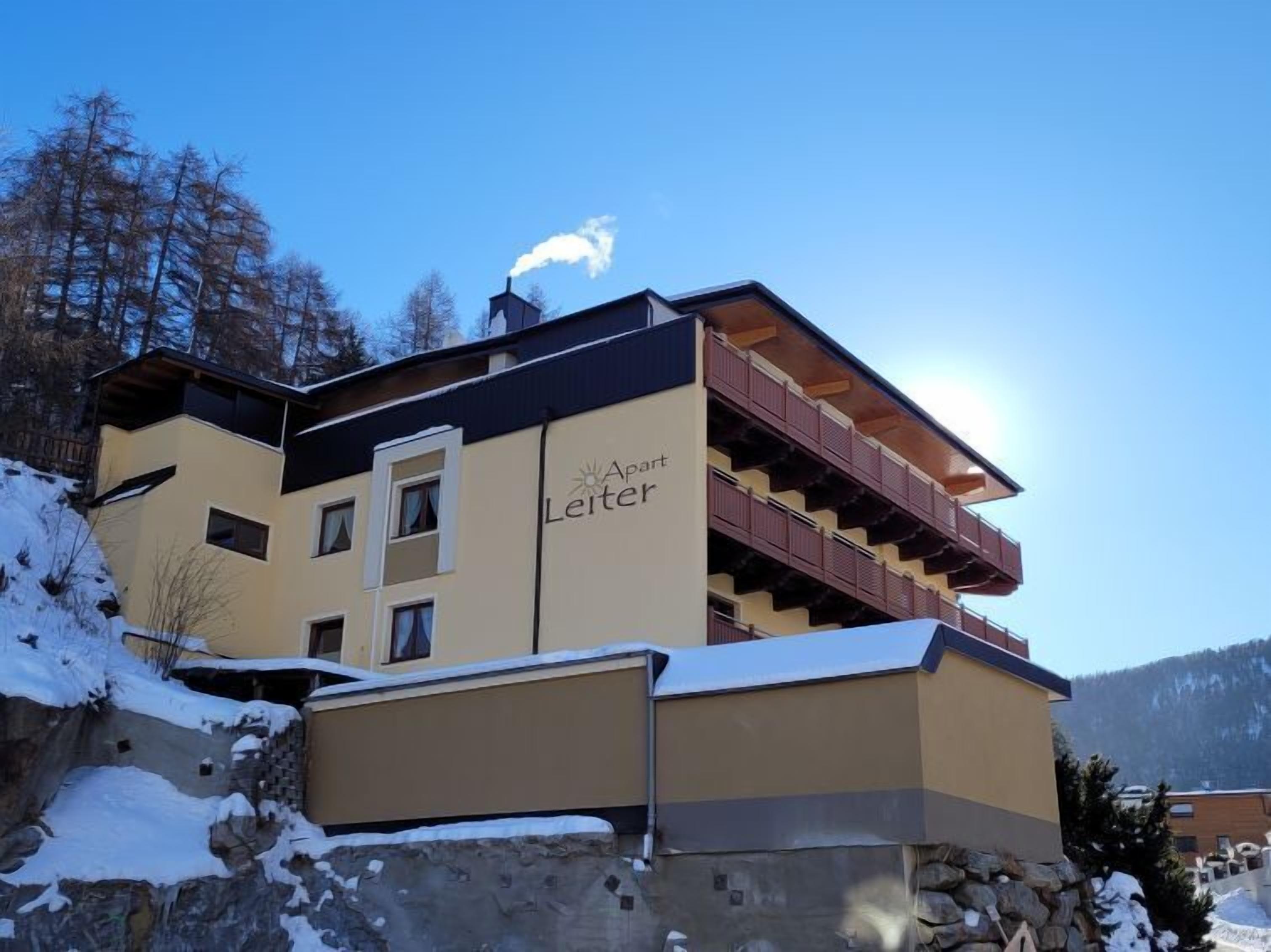 A multi-story building with a ski lift on the roof, labeled "Aust Leiter."