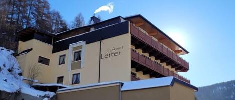 A multi-story building with a ski lift on the roof, labeled "Aust Leiter."