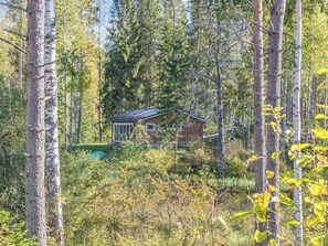A cabin surrounded by dense forest with a small deck area. - Koskisaari, vaikon loma 2 by Interhome (Kaavi)