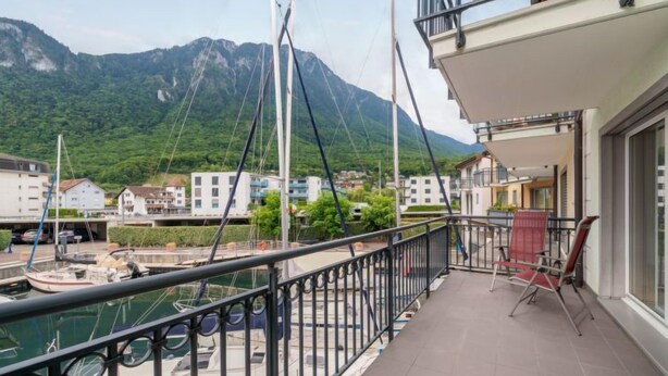 A balcony with a view of a marina and mountains.