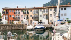 A marina with boats docked, surrounded by colorful buildings with balconies.