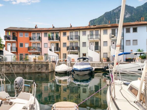 A marina with boats docked, surrounded by colorful buildings with balconies.