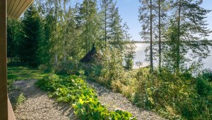 A cabin with a gravel path leading to a dock by a lake, surrounded by dense forest. - Kärkiniemi by Interhome (Tuusniemi)