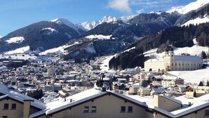 A snow-covered town with a prominent church and mountains in the background. - Disentiserhof Hönig by Interhome (Disentis)