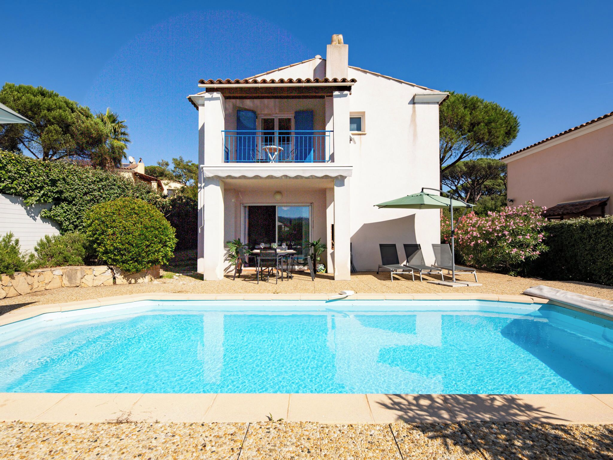 Une maison à deux étages avec une piscine à l’avant.