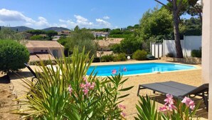 Una piscina con vista su case e vegetazione sullo sfondo.