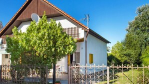 A two-story house with a brown roof and white walls, a balcony, and a satellite dish. - Vacation home Gerle by Interhome (Balatonfenyves)