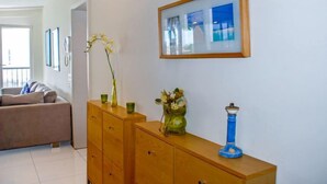 A living room with a wooden cabinet, a vase with flowers, and a framed picture on the wall. - Residenza Moro by Interhome (Ascona)
