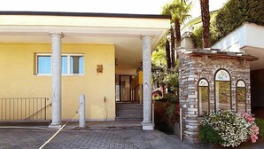 A building with a yellow facade, a stone entrance, and a staircase leading to the entrance. - Residenza Moro by Interhome (Ascona)