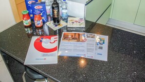 A kitchen counter with various items including a bottle of wine, condiments, and a brochure. - Residenza Moro by Interhome (Ascona)