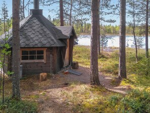 A cabin with a hexagonal roof, surrounded by trees and a lake. - Honkapirtti, vuotunki by Interhome (Kuusamo)