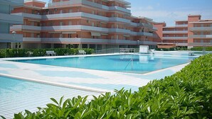 A multi-story hotel with a swimming pool, surrounded by greenery. - Valbella by Interhome (Bibione)