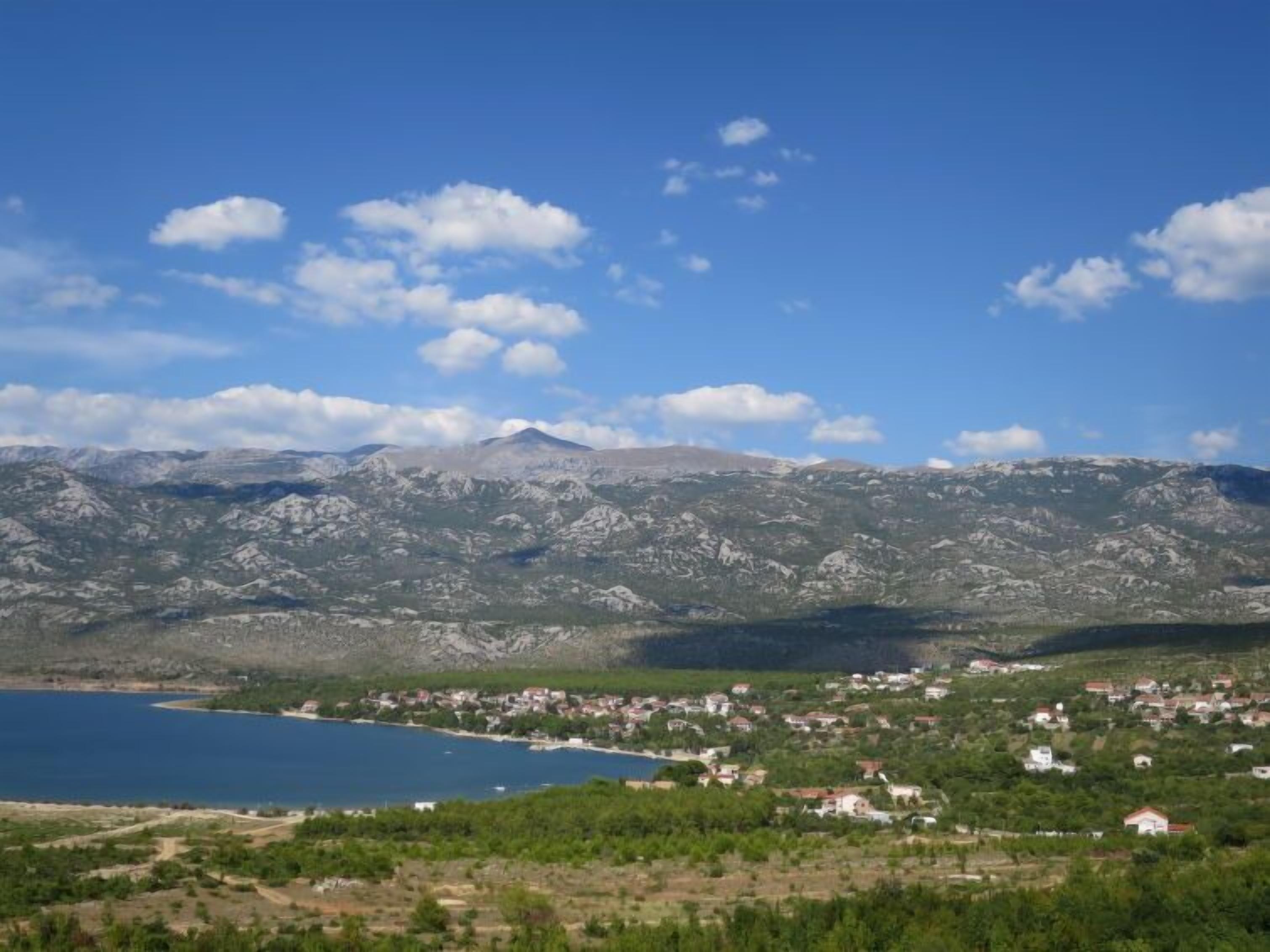 A coastal town with a mountain range in the background.